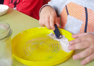 Chłopiec miesza sól na talerzyku
